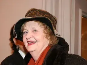 Татяна Лолова  с часовник върху шапката си и стикер за инвалиди на колата си