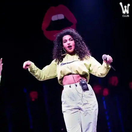 Едната близначка пее с чанта на гърдите