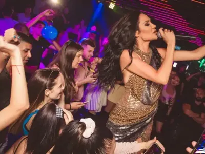 Фолкпевицата Лорена мята шотове в разкрачена поза