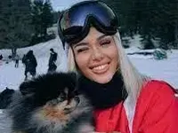 Лидия на ски с куче на ръце